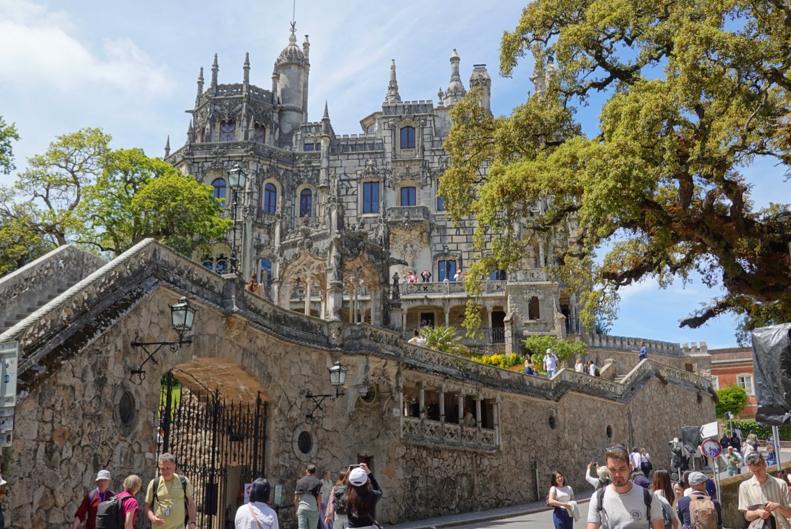 The neo-Manueline Quinta da Regaleira palace rising above stone walls and ancient trees in Sintra