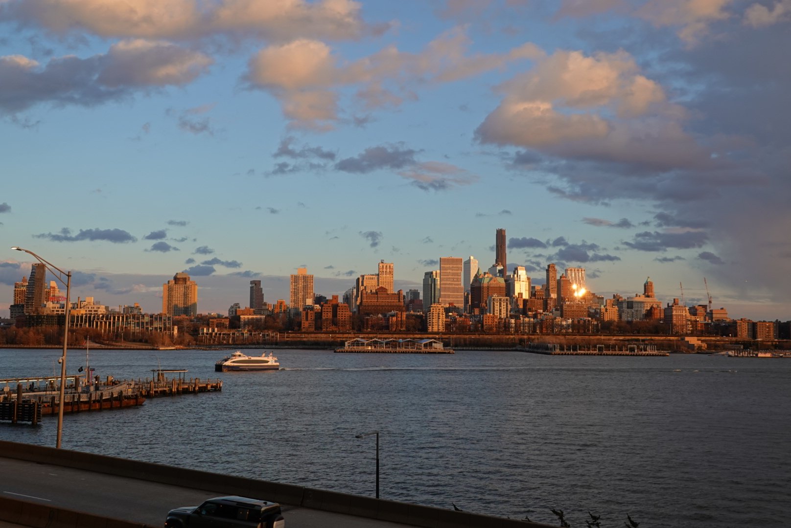 Lower Manhattan skyline glowing gold across the Hudson River at sunset